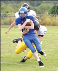  ?? Photo by Mike Eckels ?? Decatur quarterbac­k Bryson Funk protects the ball as a Jay defender latches on for the takedown during the Sept. 28 junior high game in Decatur.