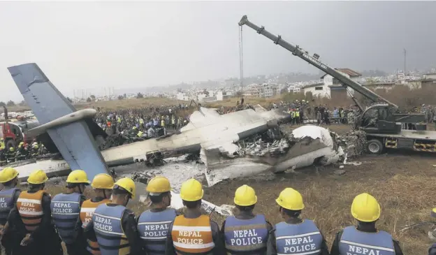  ?? PICTURE: NIRANJAN SHRESHTA/AP ?? 0 Part of the wreckage of the Us-bangla Airlines plane is lifted as rescuers wait to search for victims and for clues to the cause of the crash