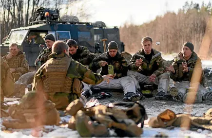  ?? AP ?? Norwegian engineers mix with members of Britain’s Royal Engineers as they eat their lunch during pre-exercise integratio­n training in Telneset, Norway.