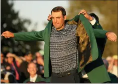  ?? JAE C. HONG — THE ASSOCIATED PRESS ?? Hideki Matsuyama, of Japan, helps Scottie Scheffler put on the green jacket after winning the 86th Masters golf tournament on Sunday in Augusta, Ga.