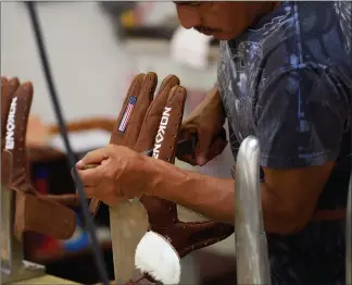  ?? Photos by Cooper Neil / Bloomberg News ?? While the top ballglove companies – Rawlings, Wilson and Mizuno – are making their gloves overseas, the Nokona Ballgame Company still makes 98 percent of its gloves in a suburb of Dallas.