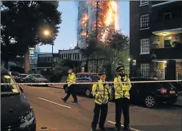  ?? Picture: AFP ?? GOING UP IN SMOKE: Police monitor a security cordon as a huge fire rips through the Grenfell Tower early yesterday in west London, where a massive blaze engulfed the 27-storey apartment block, trapping residents inside