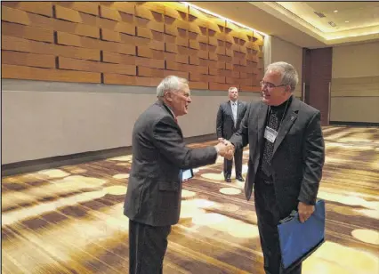  ?? TY TAGAMI / AJC ?? Gov. Nathan Deal shakes hands with Georgia School Superinten­dent Richard Woods before a recent speech to school leaders. The two are at odds over underperfo­rming schools.