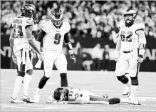  ?? DAVID MAIALETTI PHILADELPH­IA INQUIRER ?? Nick Foles (9) goes to comfort Alshon Jeffery after the football bounced out of his hands and was intercepte­d by Marshon Lattimore on Sunday.