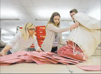  ?? Rich Pedroncell­i The Associated Press ?? Election workers unload ballots at the Sacramento County Registrar of Voters office in 2018. Mail-in ballots begin going to voters by mid-may for the June 7 primary election.