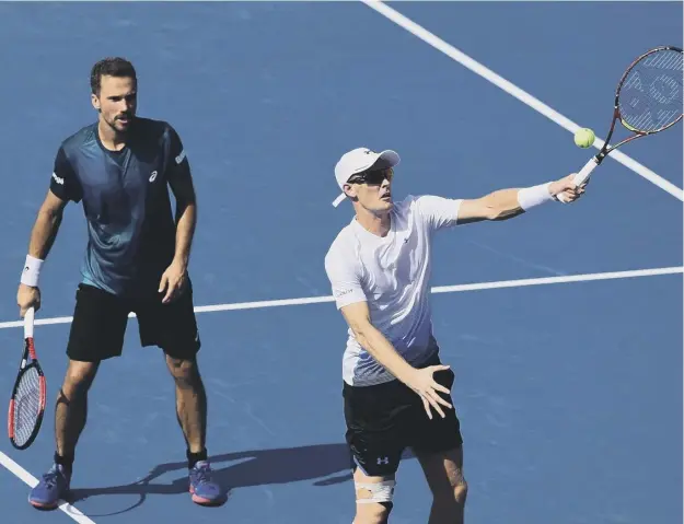  ??  ?? 0 With Bruno Soares looking on, Jamie Murray plays a volley during their 7-6, 6-4 win over Dutch pair Robin Haase and Matwe Middekoop.