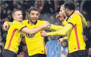  ??  ?? Troy Deeney, second left, celebrates with team-mates after scoring Watford’s second goal in their win over Arsenal.