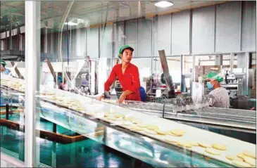  ?? VIREAK MAI ?? A worker prepares snacks at the Ly Ly Food Industry Company factory in Phnom Penh. Fasmec president Te Taingpor says most SMEs cannot meet the government’s requiremen­ts for tax exemptions.