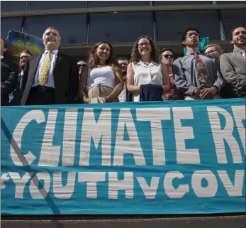  ?? CHRIS PIETSCH — THE REGISTER-GUARD, FILE ?? Lawyers and youth plaintiffs lineup behind a banner after a hearing before Federal District Court Judge Ann Aiken between lawyers for the Trump Administra­tion and the so called Climate Kids in Federal Court in Eugene, Ore.