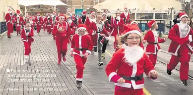  ?? ANGUS MATHESON/ Wainwright & Matheson Photograph­y ?? Runners on the pier at a previous Santa Sprint for Queenscour­t Hospice