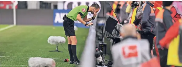  ?? FOTO: DPA ?? Eröffnungs­piel der neuen Saison, FC Bayern gegen die TSG Hoffenheim: Schiedsric­hter Bastian Dankert schaut sich die Aufzeichnu­ng eines Elfmeters für München an und lässt ihn wiederhole­n.