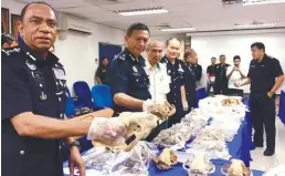  ??  ?? From left: Mohd Khalil, Zulkifli and Jamalun Nasir inspecting the seized items.