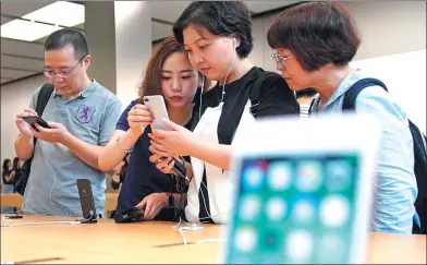  ?? REUTERS ?? Customers look at Apple's new iPhone 8 Plus after it goes on sale at an Apple Store in Shanghai.