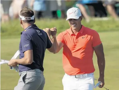  ?? STREETER LECKA/GETTY IMAGES ?? Ian Poulter, left, and Brooks Koepka congratula­te each other after both made birdie putts on the 11th green during Saturday’s round at the U.S. Open at Shinnecock Hills Golf Club.