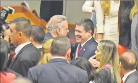  ??  ?? El presidente Cartes (d) en un efusivo saludo con el imputado Óscar González Daher (ANR) ayer en la sala bicameral del Congreso.