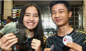  ?? — AZHAR MAHFOF / The Star ?? Second but just as happy: Aira Azman (left) and Hadith Danial Jefri showing off their runners-up medals from the British Junior Open at the KLIA yesterday.