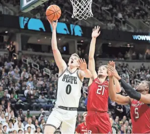  ?? KIRTHMON F. DOZIER/DETROIT FREE PRESS ?? Michigan State forward Jaxon Kohler scores against Rutgers forward Dean Reiber during the first half on Thursday in East Lansing.