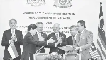  ??  ?? Najib (third right) and Lee (second left) witnessing the signing of the landmark Kuala Lumpur-Singapore High Speed Rail (HSR) Agreement in Putrajaya. — Bernama photo