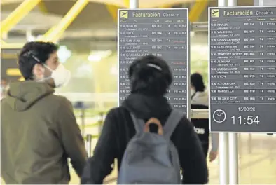  ?? EFE / VÍCTOR LERENA ?? Una pareja observa los paneles de informació­n, en Barajas.