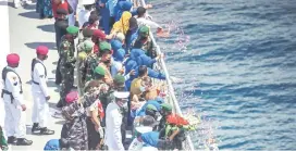  ?? — AFP photo ?? Family members throw flowers into the sea during a remembranc­e ceremony for the crew of the Indonesian navy submarine KRI Nanggala on the deck of the hospital ship KRI Dr Soeharso off the coast of Bali.