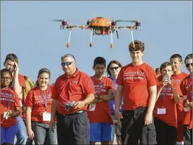  ?? BILL LACKEY / STAFF ?? Frank Beafore (center) demonstrat­es a UAV his company designs and manufactur­es for youth from an Air Camp at Springfiel­d Bexley Municipal Airport.