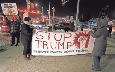  ?? RICK WOOD / MILWAUKEE JOURNAL SENTINEL ?? A group of about 15 to 20 protesters shout “Dump Trump” while marching Tuesday night near S. 84 St. and W. Greenfield Ave. before President-elect Donald Trump speaks to supporters nearby at the State Fair Park Exposition Center.