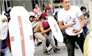  ??  ?? Demonstrat­ors clash with riot security forces during a rally against Maduro’s government in Caracas,Venezuela. — Reuters photo