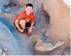  ?? PETER HOUDE/NMSU ?? Jude Sparks crouches next to the Stegomasto­don fossil he found near Las Cruces.