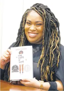  ?? ROGELIO V. SOLIS/AP ?? Angie Thomas with her novel, “The Hate U Give,” at an October 2018 book signing in Jackson, Mississipp­i. The book, a bestseller about a Black teen murdered by police, was adapted into a feature film.