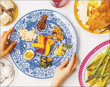  ?? PHOTOS BY MATT TAYLOR-GROSS ?? Jake Cohen’s Seder plate features updated symbolic foods, and a modern addition. In the center, orange segments represent solidarity with the LGBTQ+ community.