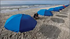  ?? (AP Images for Visit Myrtle Beach/Mic Smith) ?? Socially distanced umbrellas offer shade July 30 along the coastline in Myrtle Beach.