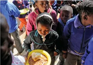  ?? PICTURE: INDEPENDEN­T MEDIA ARCHIVES ?? MEAL OF THE DAY: Pupils receive their food at Megatong Primary School in Soweto.