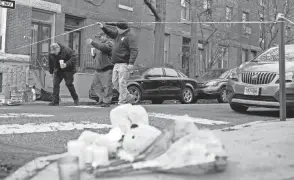  ?? ?? Officials pass flowers and other items left in memory of victims of Wednesday’s fatal fire in the Fairmount neighborho­od of Philadelph­ia on Thursday. Officials say it’s the city’s deadliest single fire in at least a century.