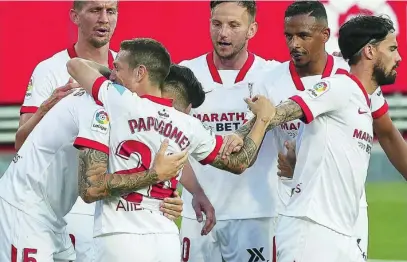  ?? EFE ?? Ocampos y el Papu Gómez se abrazan tras uno de los dos goles que el Sevilla le marcó al Granada