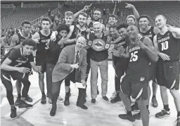  ?? ETHAN MILLER/GETTY IMAGES ?? MGM Resorts executive George Kliavkoff, center, presents Colorado head coach Tad Boyle and his team with the championsh­ip belt at the MGM Resorts Main Event on Nov. 26, 2019, in Las Vegas, Nevada.