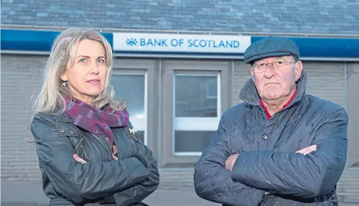  ?? Photograph by Jason Hedges ?? MONEY: Community councillor­s Carolle Ralph and Mike Mulholland at Lossiemout­h Bank of Scotland.