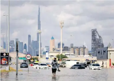  ?? ?? Con el Burj Khalifa de fondo, las calles de Dubái lucen bajo el agua con autos anegados