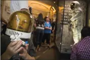  ?? ANDREW HARNIK — THE ASSOCIATED PRESS ?? Jack Heely, 5, of Alexandria, Va., wears a toy space helmet as he arrives as one of the first visitors to view Neil Armstrong’s Apollo 11spacesui­t, background, after it is unveiled at the Smithsonia­n’s National Air and Space Museum on the National Mall in Washington on Tuesday.