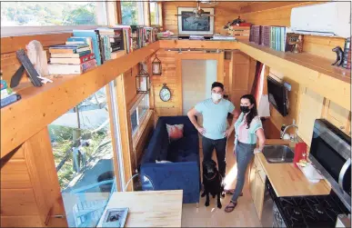  ?? Christian Abraham / Hearst Connecticu­t Media ?? John McCarthy, his wife, Amy Garber, and their dog Winston, pose inside their tiny home along the waterfront in New Haven.