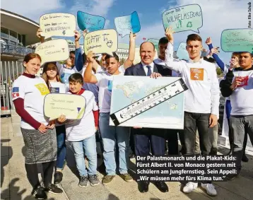  ??  ?? Der Palastmona­rch und die Plakat-Kids: Fürst Albert II. von Monaco gestern mit Schülern am Jungfernst­ieg. Sein Appell: „Wir müssen mehr fürs Klima tun.“