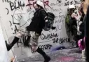  ?? AP FILE ?? OUT OF CONTROL: A protester kicks in barriers at the federal courthouse in Portland, Ore.