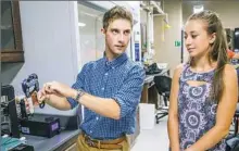  ?? Andrew Rush/Post-Gazette ?? Duquesne biomedical engineerin­g students Garett Craig and Tori Kocsis demonstrat­e a tool they created for the zip-tie challenge in NASA's Micro-g NExT competitio­n.