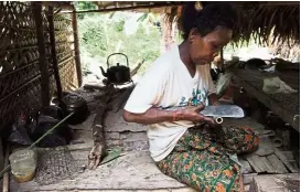  ??  ?? A resident of Kampung Aur making a souvenir blowipe.