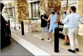  ?? (NWA Democrat-Gazette/Lynn Atkins) ?? Carla Weeks (center) motions toward a van filled with boxes going to hospital employees at the entrance to Mercy Hospital last week.