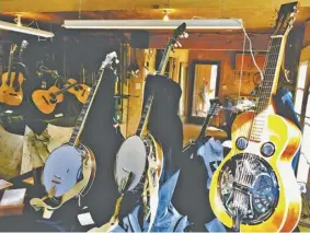 ??  ?? Handmade guitars, banjos, mandolins, and resonators are displayed at Steve’s woodshop.