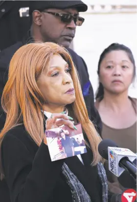  ?? Michael Macor / The Chronicle ?? The Rev. Aurea Lewis, co-founder of Urojas Community Services, holds a photo of her brother Edwarn Anderson, 64, who died in this week’s fire at a West Oakland halfway house. Behind her are the Rev. Jasper Lowery, co-founder of Urojas, and Alice...