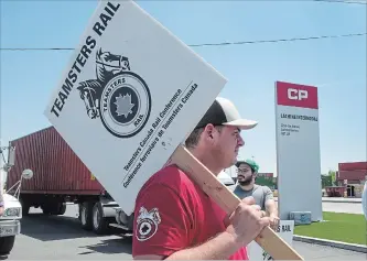  ?? RYAN REMIORZ THE CANADIAN PRESS ?? Canadian Pacific Railway workers picket at the company’s intermodal terminal Wednesday in Montreal. The Calgary-based rail giant and the Teamsters Canada Rail Conference reached a four-year deal hours later.