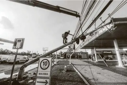  ?? Pedro Pardo / AFP / Tribune News Service ?? A worker repairs a street light damaged by Hurricane Delta on Thursday in Cancun, Mexico. After crossing the Yucatán Peninsula onWednesda­y, Delta is expected to strike Louisiana on Friday afternoon or evening.