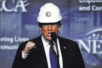  ?? Matt Rourke Associated Press ?? President Donald Trump pumps his fist Oct. 2 after putting on a hard hat given to him before speaking to the National Electrical Contractor­s Associatio­n Convention at the Pennsylvan­ia Convention Center in Philadelph­ia.