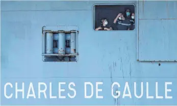  ?? FOTO: CHRISTOPHE SIMON/DPA ?? Französisc­he Marinesold­aten mit Mundschutz an Bord des Flugzeugtr­ägers „Charles de Gaulle“, während dieser im südfranzös­ischen Hafen von Toulon eintrifft.